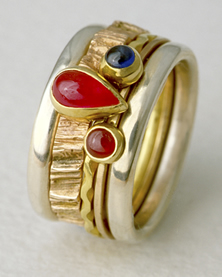 'Stacking Ring multi-stone' in silver and golds with two Rubies and a Sapphire